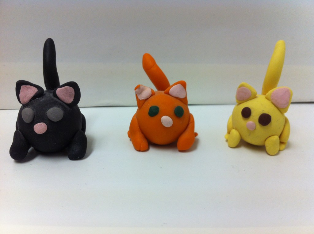 Photo of three Sculpey clay cats, obviously make by a child.